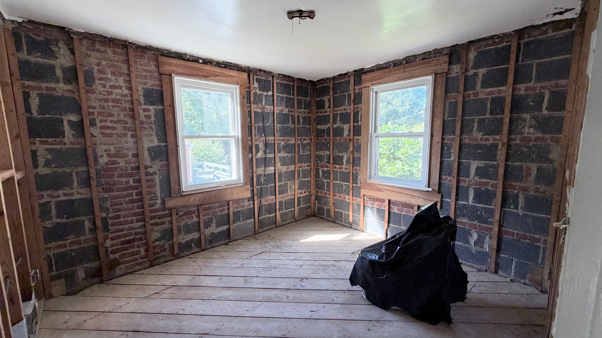 Main-level bedroom stripped to the brick and block walls