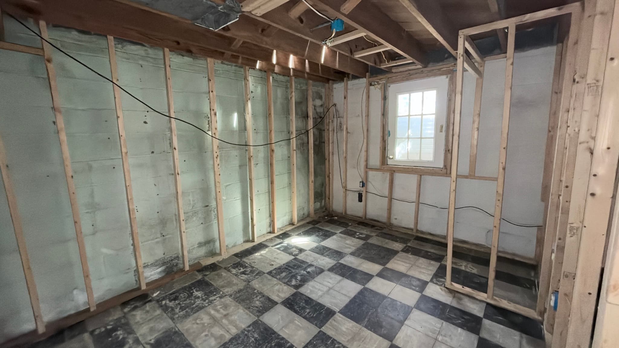 Lower level — new stud partitions over the original tile floor