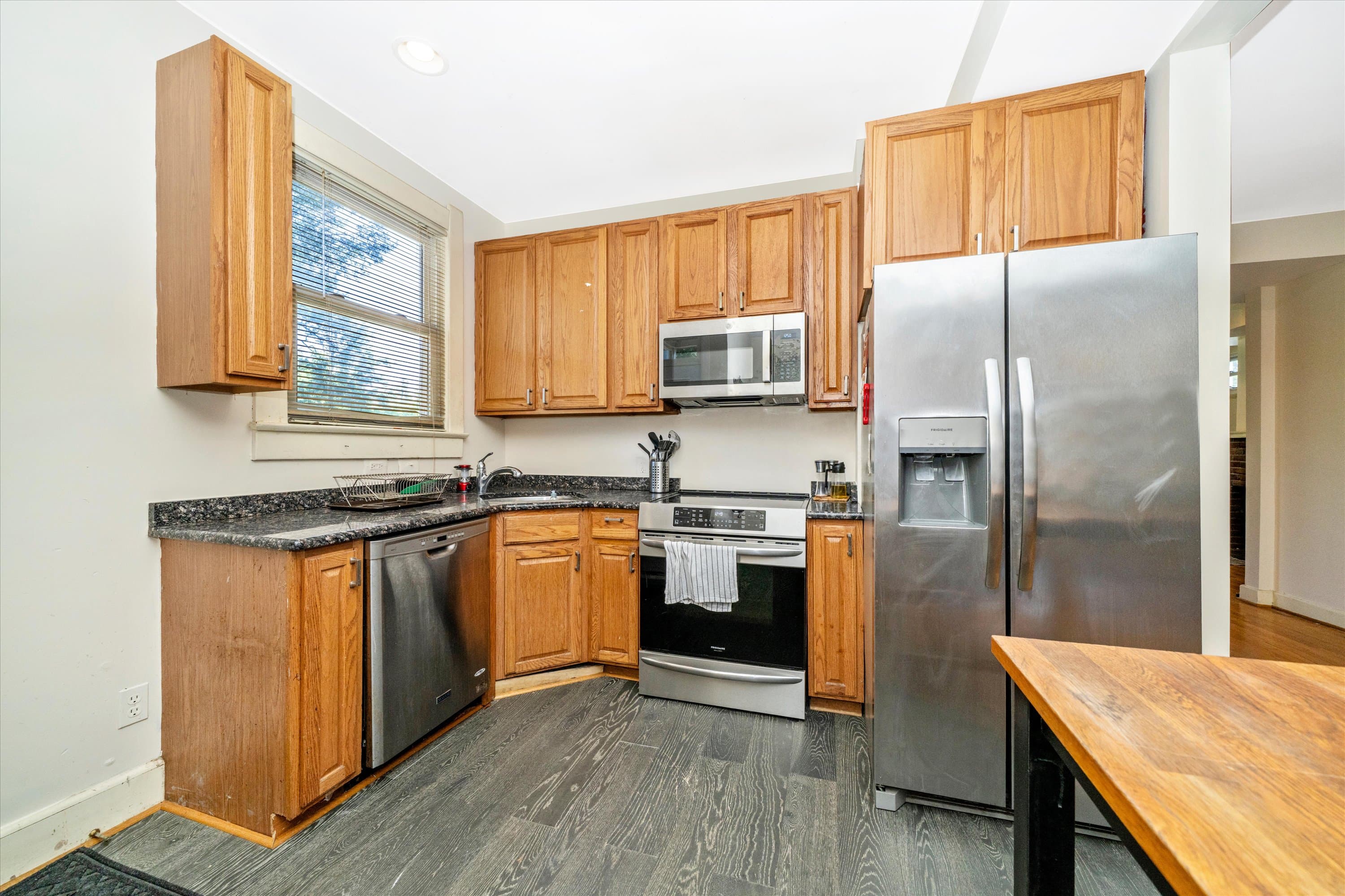 Gourmet kitchen with granite counters, wood cabinets, and stainless appliances at 3034 South Dakota Ave NE