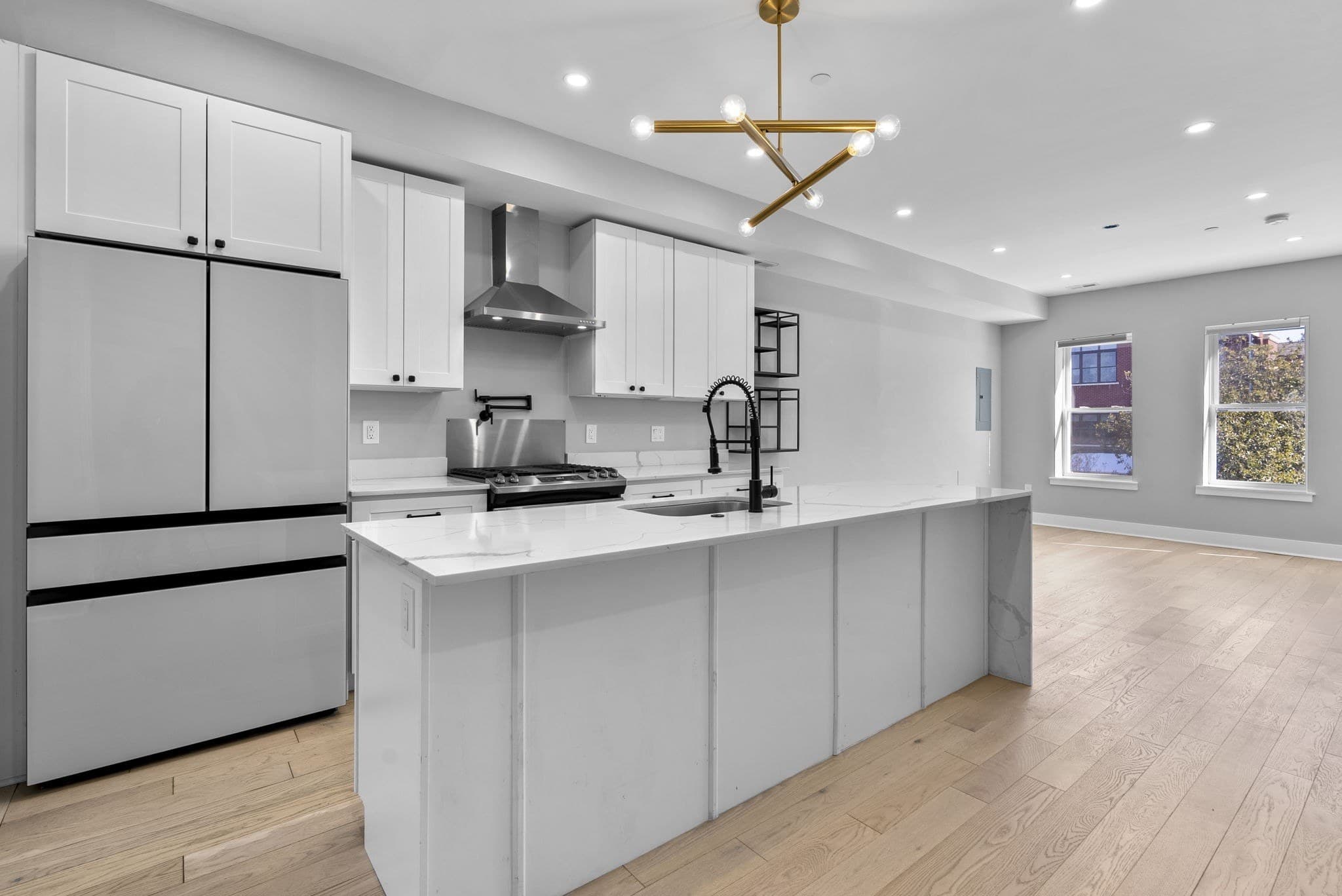 Gourmet kitchen with a waterfall quartz island and gas cooking at 3572 13th St NW #2, Columbia Heights, Washington DC