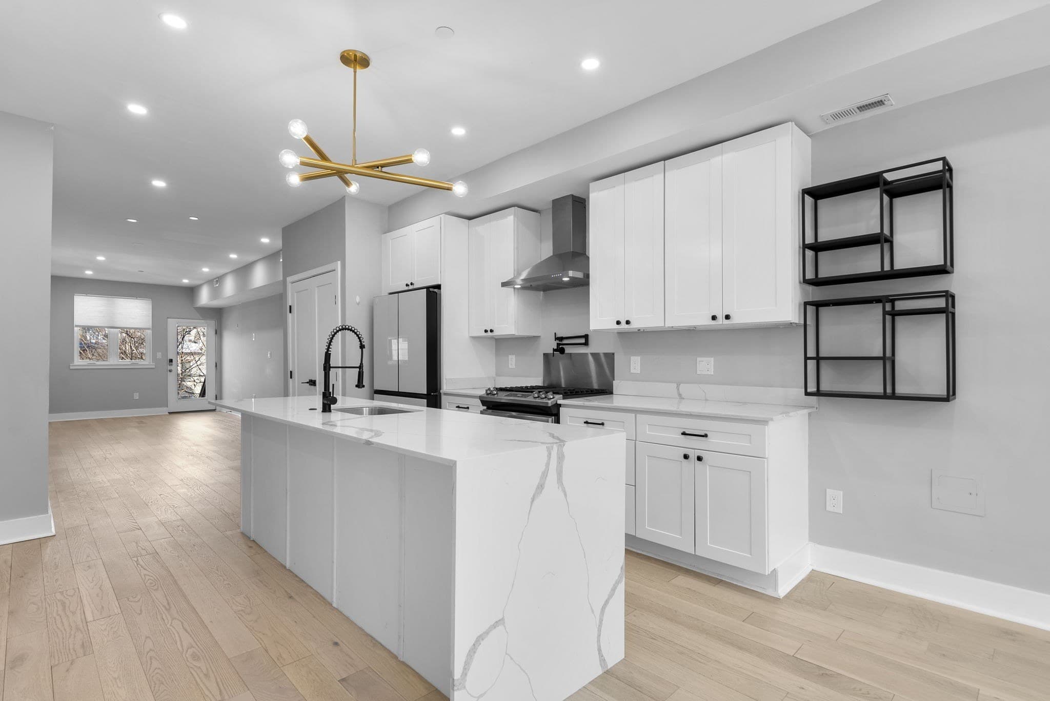 Kitchen with gas range, stainless appliances, and open shelving at 3572 13th St NW #2