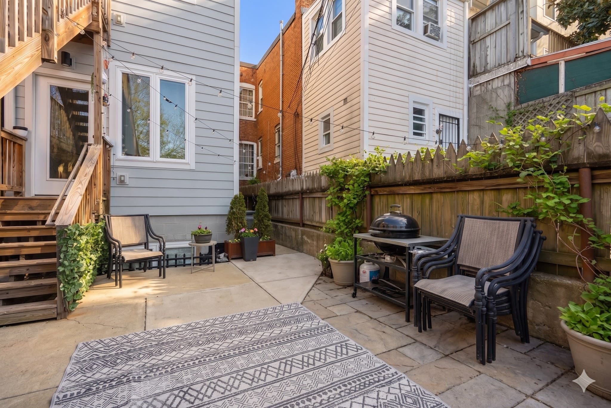 Private rear patio with string lights and direct dining room access at 3572 13th St NW #2