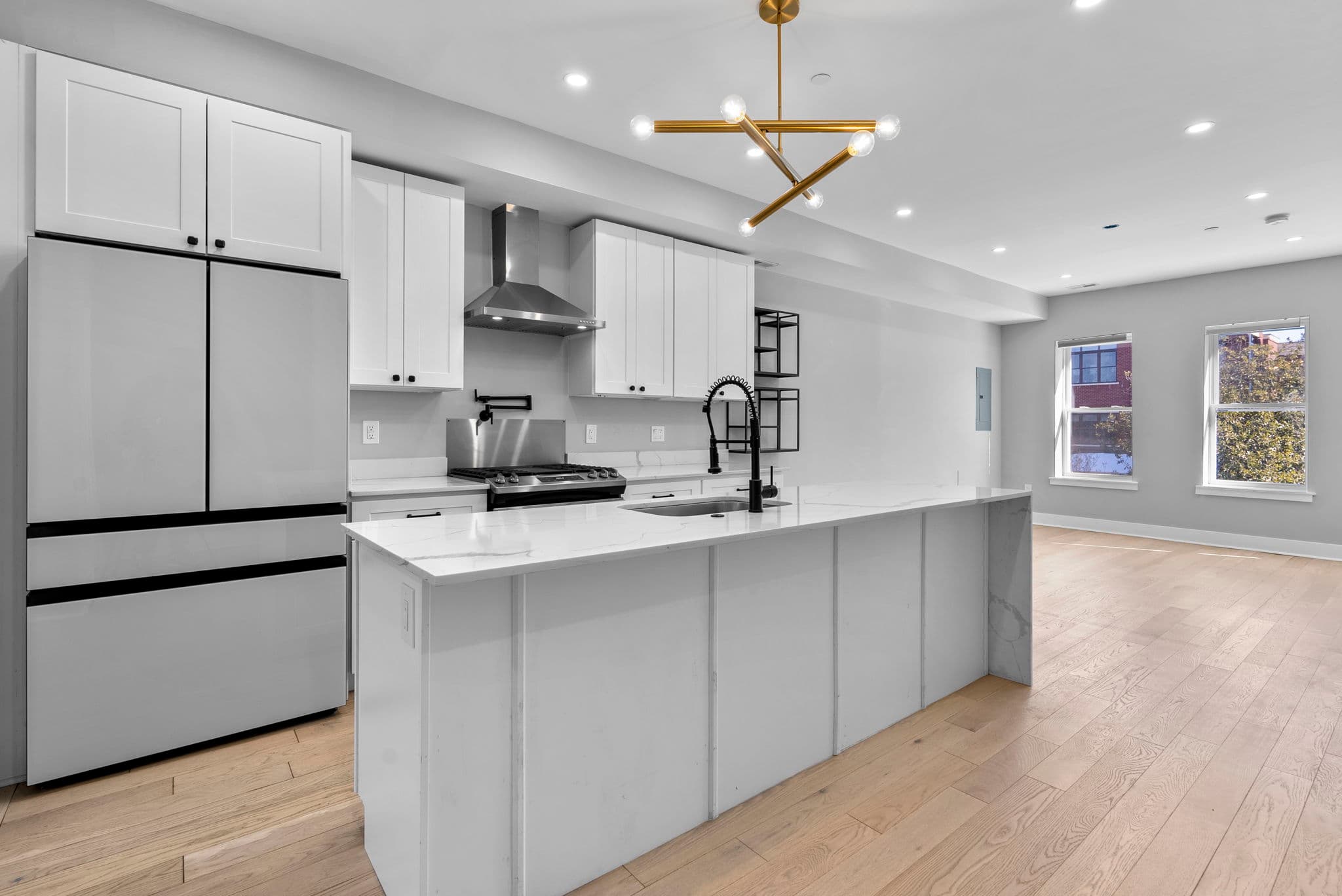 Gourmet kitchen with waterfall quartz island and gas cooking at 3572 13th St NW #2, Columbia Heights DC